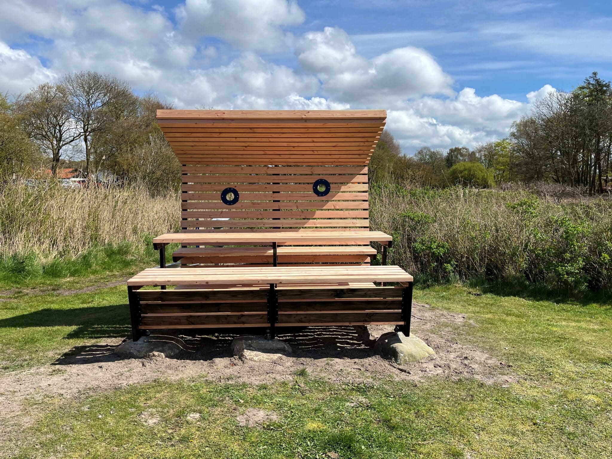 Hævet bordbænkesæt med halvåben overdækning hos Øhavsstien. Af ubehandlet douglas.